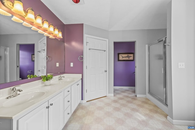 bathroom featuring a sink, a stall shower, baseboards, and tile patterned floors
