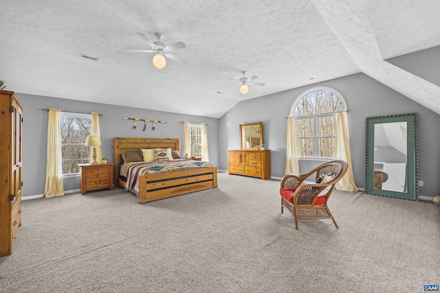 bedroom with multiple windows, a textured ceiling, visible vents, and lofted ceiling