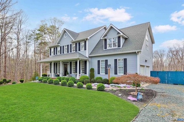 view of front facade with an attached garage, fence, a front lawn, a porch, and driveway