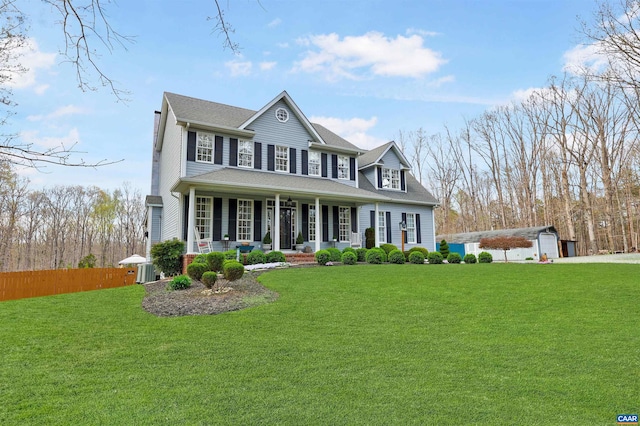 view of front of home featuring covered porch, fence, a front lawn, and central AC unit