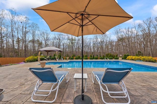 pool with a gazebo, fence, and a patio