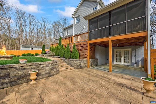 rear view of house with a patio area, a sunroom, french doors, and fence