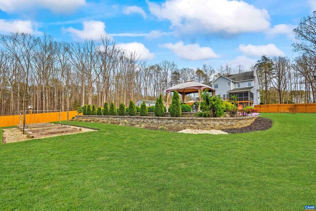 view of yard with a gazebo, fence, and a garden