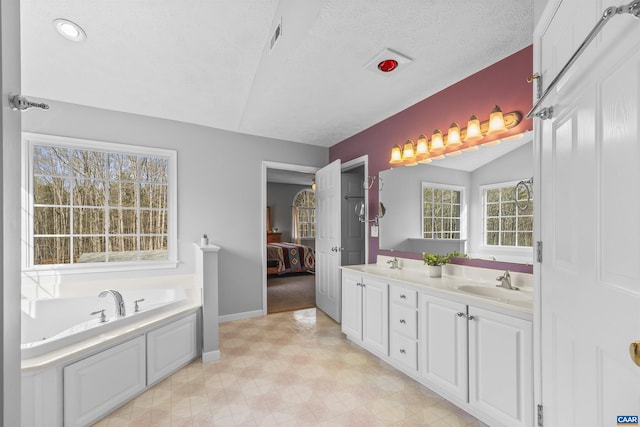 bathroom featuring a sink, double vanity, ensuite bathroom, and a bath