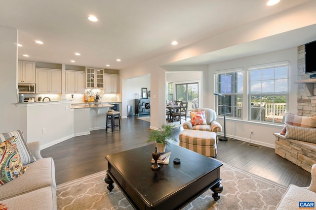 living area with wood finished floors, recessed lighting, and baseboards