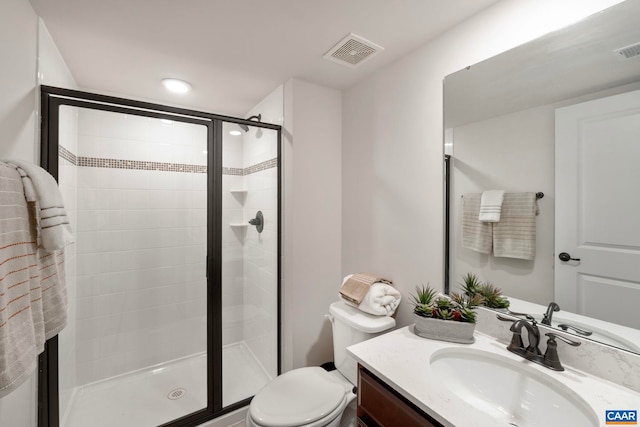 bathroom with a stall shower, vanity, and toilet