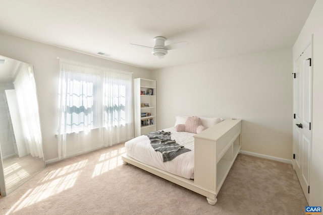 bedroom featuring light colored carpet, a ceiling fan, and baseboards