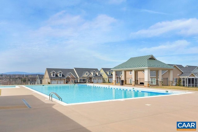 community pool featuring fence, a gazebo, and a patio area