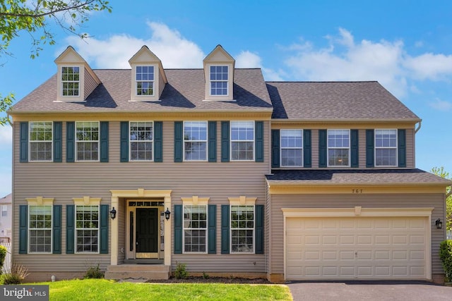 colonial house with aphalt driveway and a garage