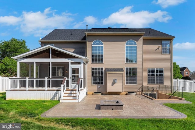 back of house featuring a yard, a patio area, a sunroom, and fence