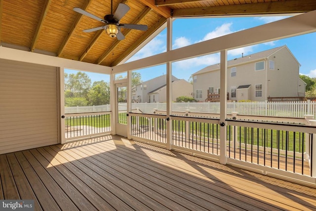 wooden terrace featuring a fenced backyard, a lawn, ceiling fan, and a residential view