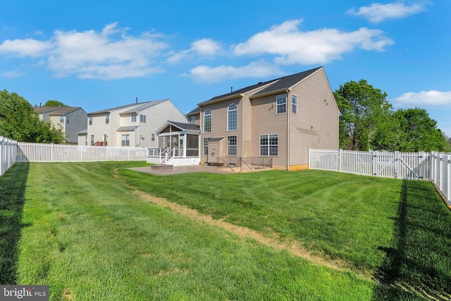 back of house with a yard, a patio, a sunroom, and a fenced backyard