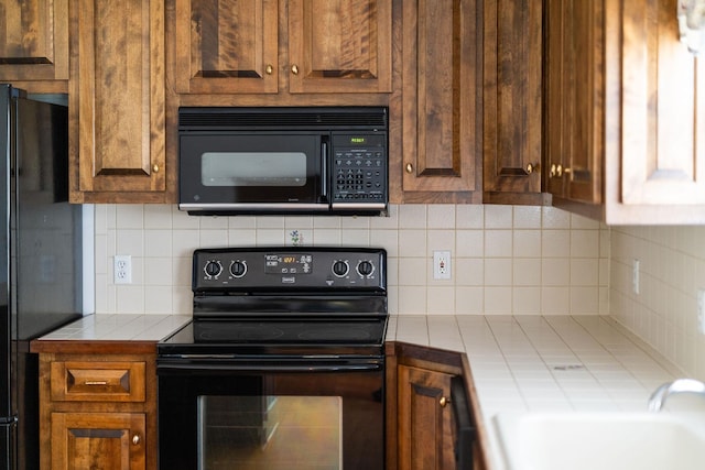 82 Pheasant Run, Waynesboro, VA 22980 - kitchen featuring black appliances, tile counters, tasteful backsplash, and a sink
