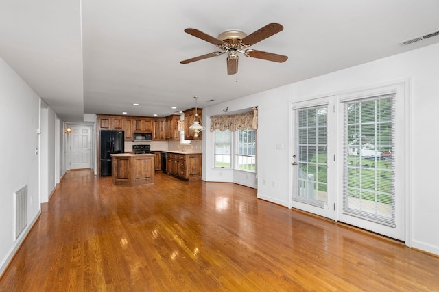 82 Pheasant Run, Waynesboro, VA 22980 - kitchen with black appliances, brown cabinets, a center island, dark wood-style flooring, and a ceiling fan