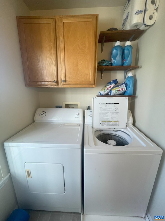 1520 Villa Ter Unit E, Charlottesville, VA 22903 - clothes washing area featuring washer and clothes dryer, tile patterned flooring, and cabinet space