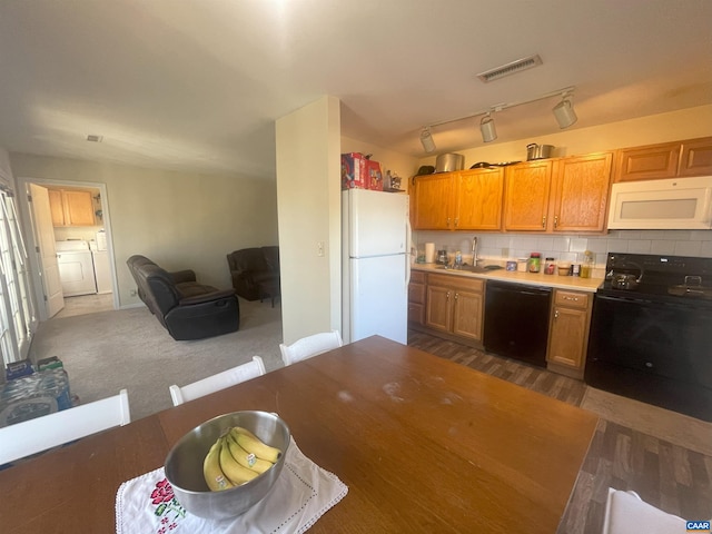 1520 Villa Ter Unit E, Charlottesville, VA 22903 - kitchen featuring washer and dryer, visible vents, a sink, backsplash, and black appliances