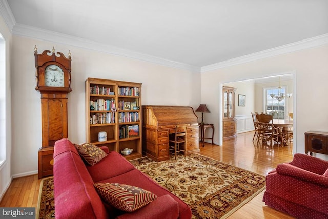 living room with a notable chandelier, ornamental molding, and wood finished floors