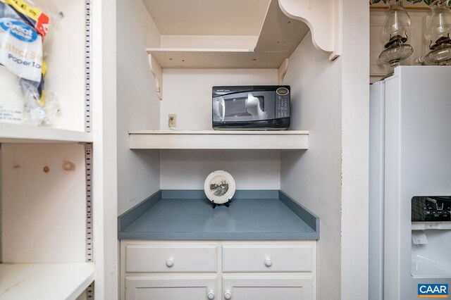 5722 James River Rd, Gladstone, VA 24553 - kitchen view of white refrigerator with ice dispenser, black microwave, and white cabinetry