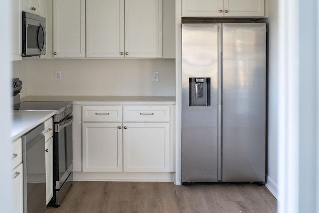 208 Weaver St, Gordonsville, VA 22942 - kitchen featuring white cabinets, light countertops, light wood-style floors, and stainless steel appliances