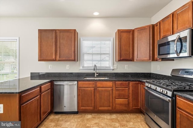 35367 Pheasant Ridge Rd, Locust Grove, VA 22508 - kitchen with stainless steel appliances, a peninsula, dark stone counters, recessed lighting, and brown cabinetry
