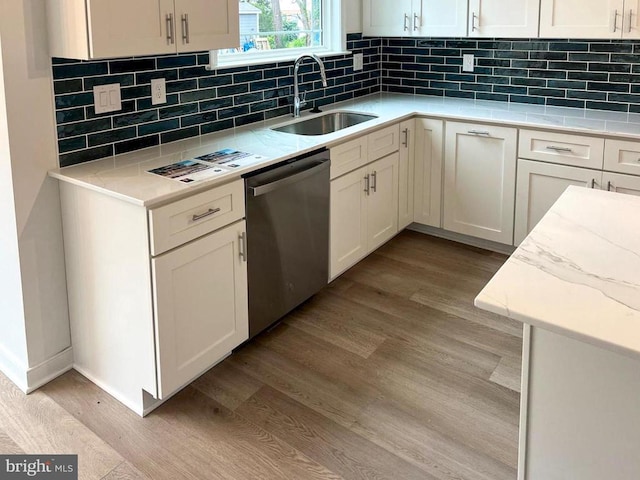kitchen with dishwasher, a sink, light wood-style flooring, and decorative backsplash