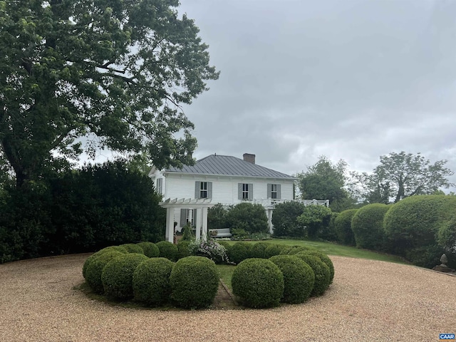 10064 Hatton Ferry Ln, Scottsville, VA 24590 - view of front of home featuring a chimney, a pergola, metal roof, and a standing seam roof