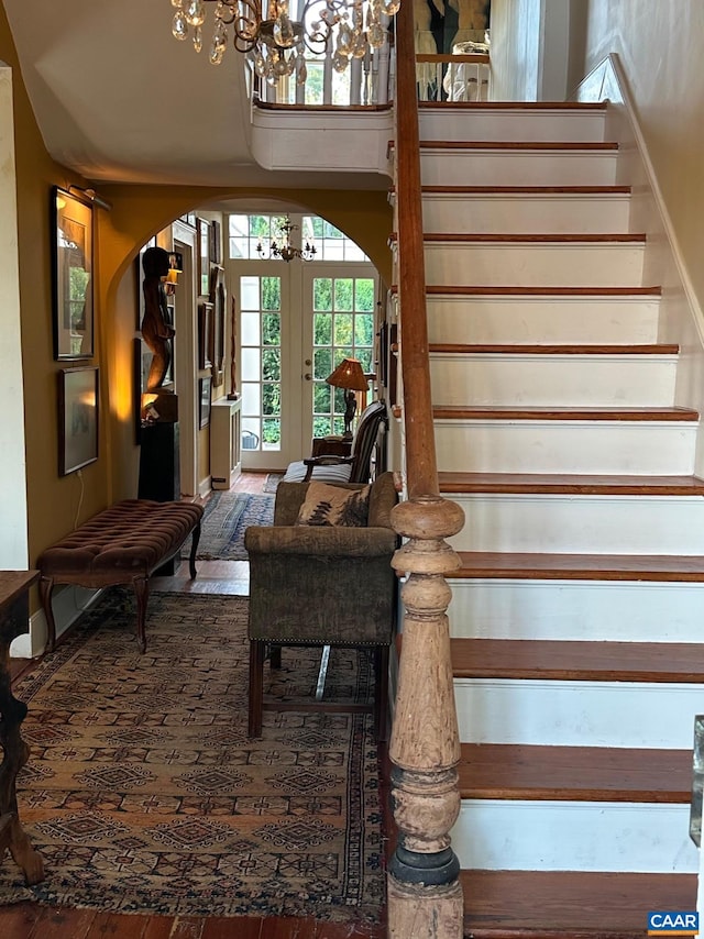 10064 Hatton Ferry Ln, Scottsville, VA 24590 - stairway with arched walkways, a chandelier, french doors, and wood finished floors
