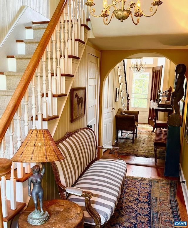 10064 Hatton Ferry Ln, Scottsville, VA 24590 - staircase with arched walkways, a chandelier, hardwood / wood-style flooring, and baseboards