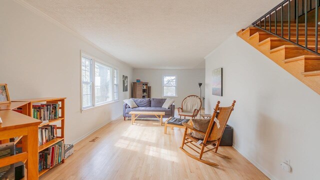 1217 Windsor Rd, Harrisonburg, VA 22801 - sitting room with wood finished floors, crown molding, a textured ceiling, baseboards, and stairs