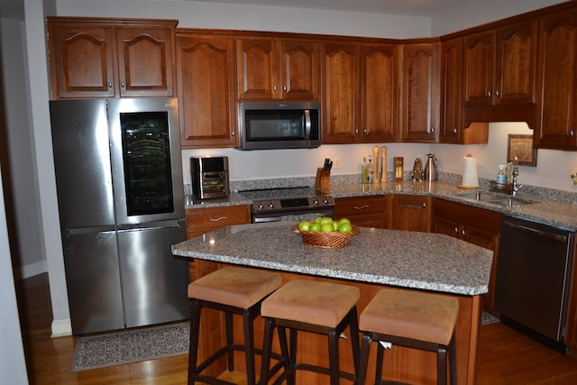 2894 Cullison Ct, Rockingham, VA 22801 - kitchen with appliances with stainless steel finishes, a sink, a breakfast bar area, wood finished floors, and light stone counters
