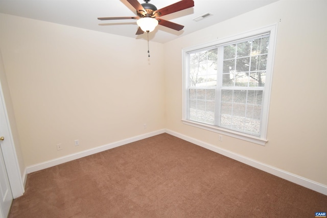 carpeted empty room with ceiling fan, baseboards, and visible vents