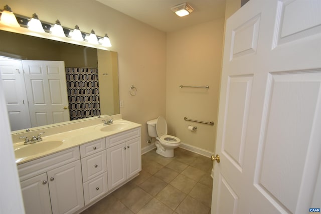 bathroom with toilet, tile patterned floors, double vanity, and a sink