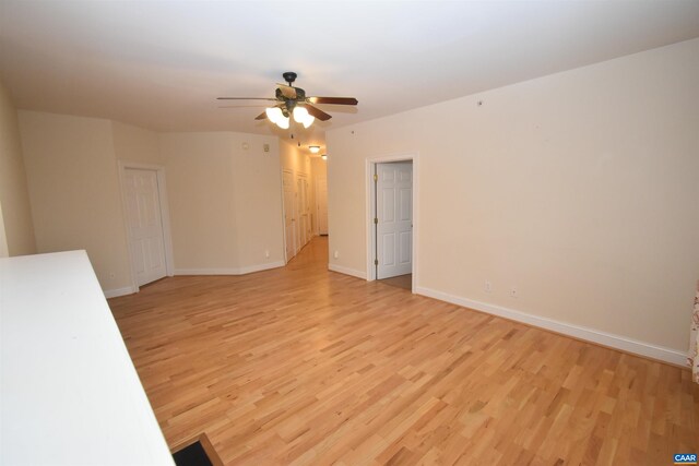 empty room featuring ceiling fan, baseboards, and light wood-type flooring