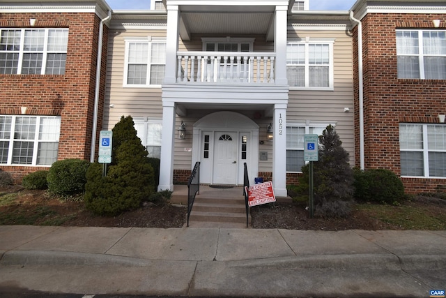 multi unit property featuring brick siding and a balcony