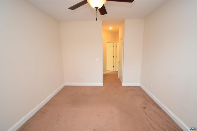 empty room featuring light carpet, baseboards, and ceiling fan