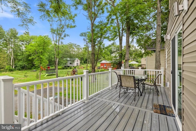 8558 Opal Rd, Warrenton, VA 20186 - wooden deck featuring outdoor dining area, a lawn, a playground, and view of scattered trees