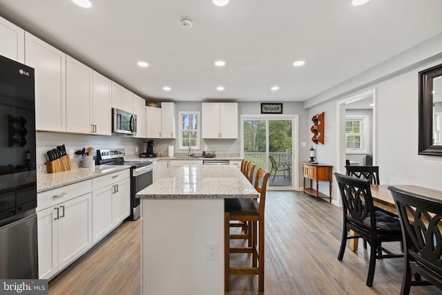 8558 Opal Rd, Warrenton, VA 20186 - kitchen featuring stainless steel appliances, a breakfast bar area, recessed lighting, a center island, and white cabinetry