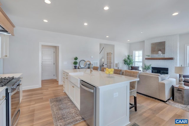 300 Fowler St, Charlottesville, VA 22901 - kitchen with appliances with stainless steel finishes, a sink, a kitchen breakfast bar, light wood finished floors, and light countertops