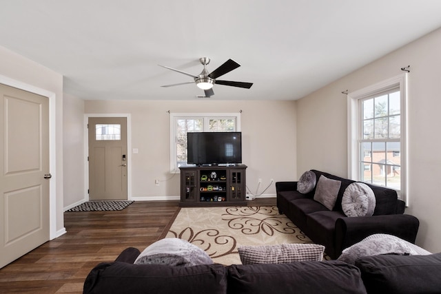 living area with a ceiling fan, baseboards, and wood finished floors