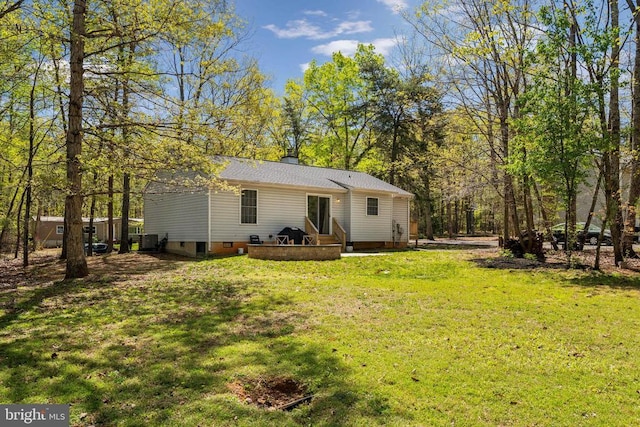 rear view of house featuring a lawn and crawl space
