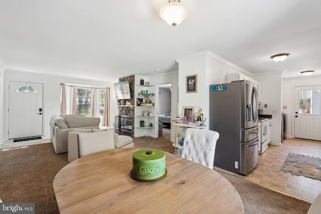 dining area with light colored carpet, ornamental molding, and washer / dryer