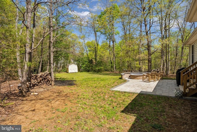 view of yard featuring an outdoor structure, a patio, a fire pit, and a shed