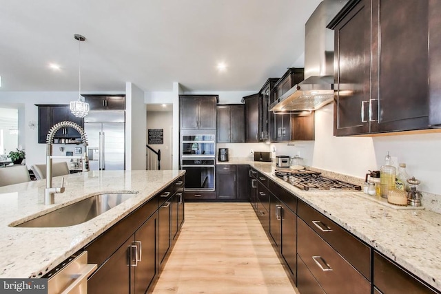 13001 Wipple Ct, Fredericksburg, VA 22407 - kitchen featuring stainless steel appliances, light wood-style flooring, extractor fan, light stone countertops, and dark brown cabinetry