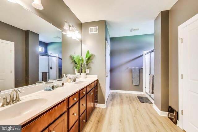13001 Wipple Ct, Fredericksburg, VA 22407 - bathroom with wood finished floors, double vanity, and a shower stall