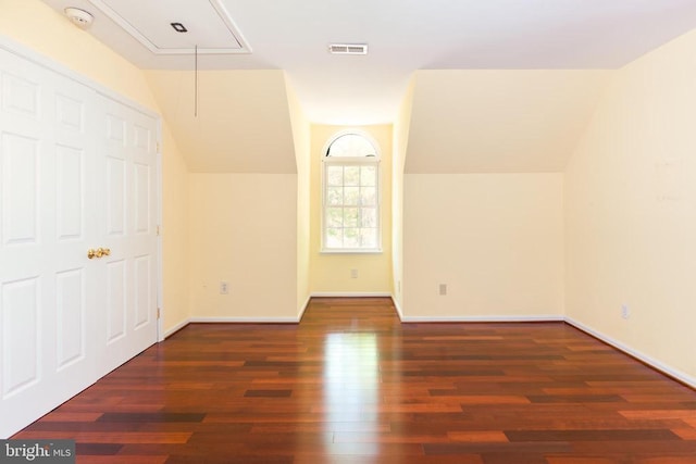 additional living space with attic access, vaulted ceiling, wood finished floors, and baseboards