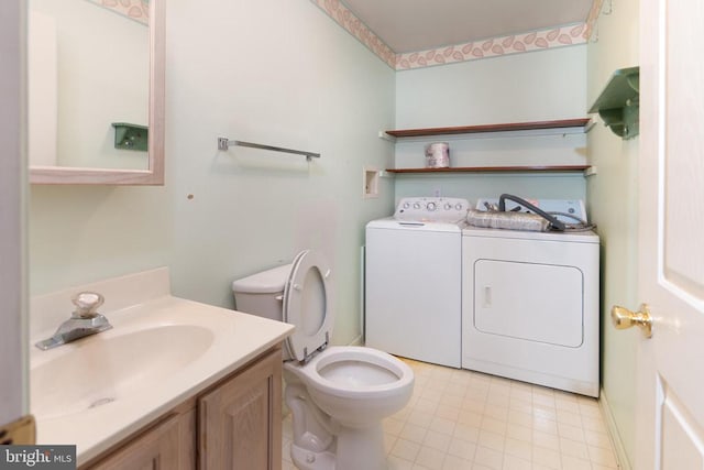 bathroom featuring vanity, toilet, independent washer and dryer, and tile patterned flooring