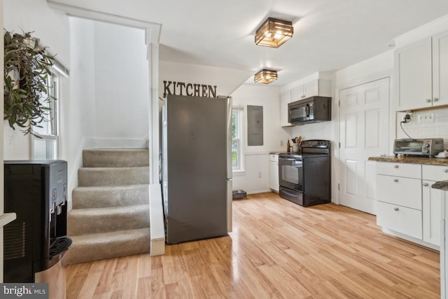 12051 Duey Rd N, Remington, VA 22734 - kitchen featuring electric panel, light wood-type flooring, black appliances, a toaster, and white cabinets