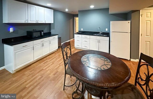 12107 Knight Ct, Fredericksburg, VA 22407 - kitchen featuring freestanding refrigerator, black microwave, baseboards, a sink, and light wood-type flooring