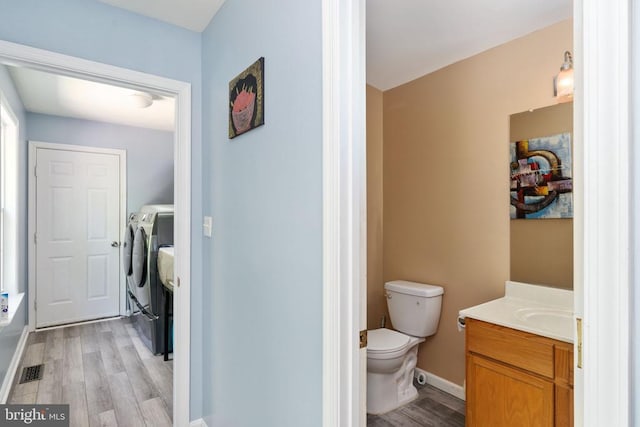 12107 Knight Ct, Fredericksburg, VA 22407 - bathroom featuring wood finished floors, washing machine and dryer, toilet, vanity, and baseboards