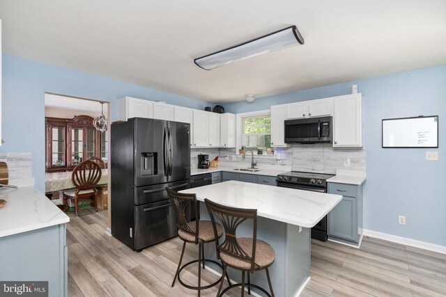 12107 Knight Ct, Fredericksburg, VA 22407 - kitchen with black refrigerator with ice dispenser, range with electric stovetop, a sink, backsplash, and a breakfast bar